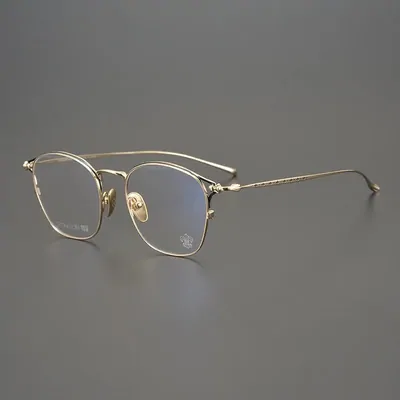 A pair of round thin-rimmed metal glasses with clear lenses, standing on a plain grey background
